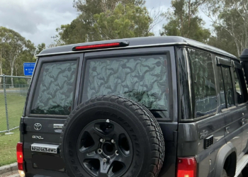 A Toyota LandCruiser 70 Series with reflective material blocking its rear windows
