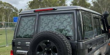 A Toyota LandCruiser 70 Series with reflective material blocking its rear windows