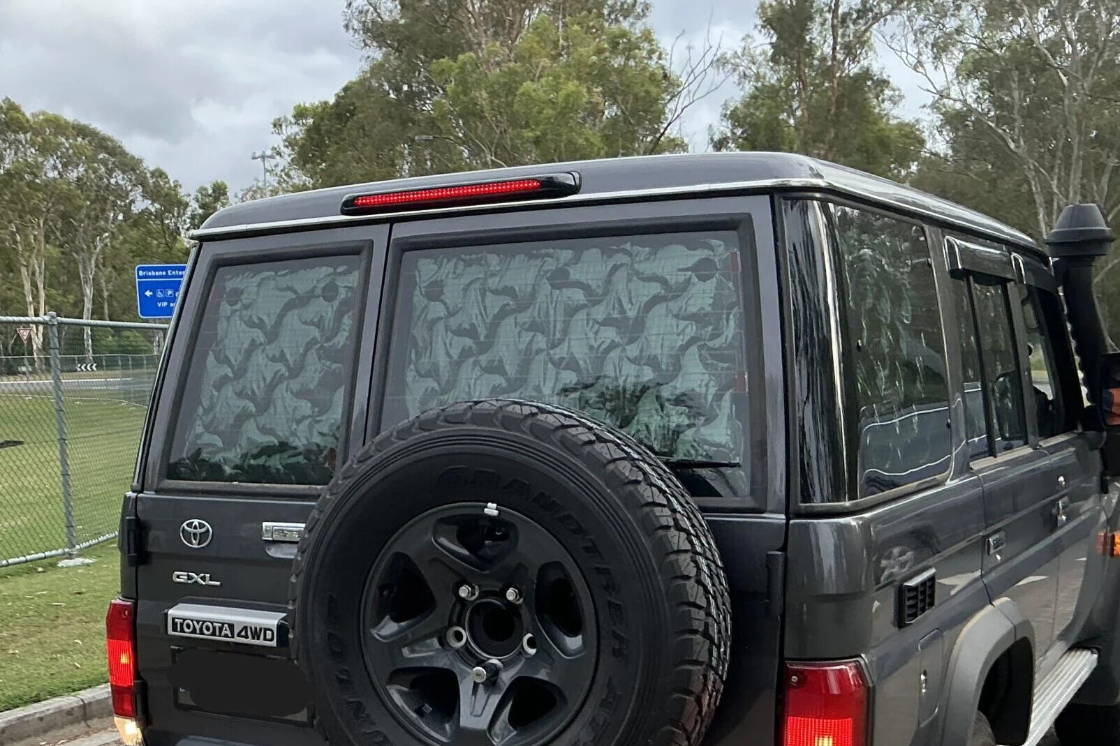 A Toyota LandCruiser 70 Series with reflective material blocking its rear windows